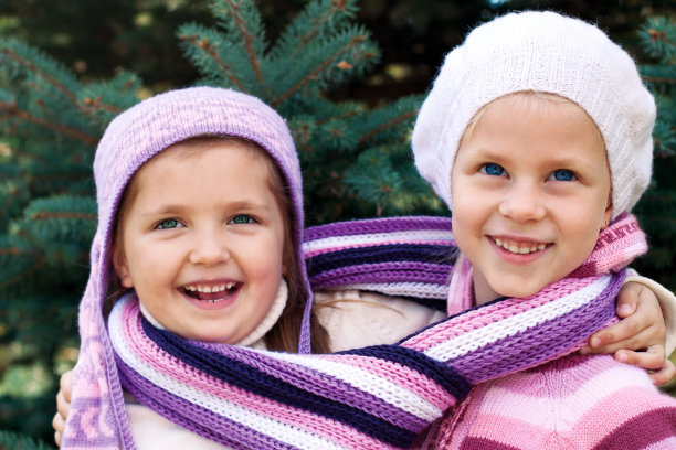 两个小女孩在圣诞树旁拥抱图片下载