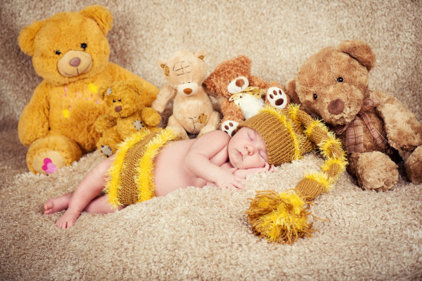 新生儿在玩具上睡觉的背景。图片下载