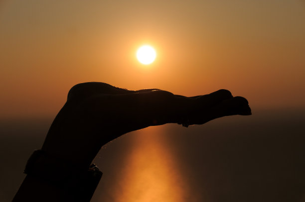 在日落时张开手推着太阳图片下载