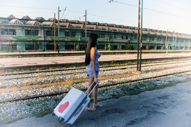 美丽的女孩带着行李在火车站图片下载