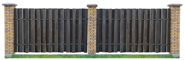用棕色木板做的栅栏。用不平整的黄砖砌成的柱子。地基是混凝土做的。孤立的白色拼贴图片下载
