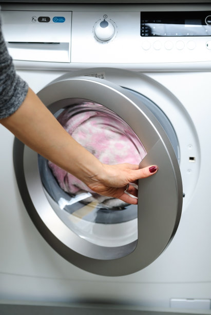 用手打开洗衣机的门。图片下载