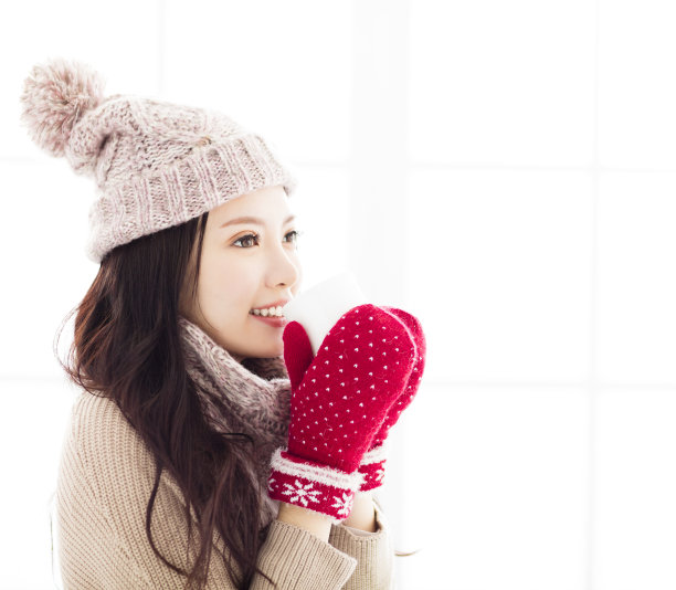 穿着冬衣喝着热饮的年轻女子图片下载