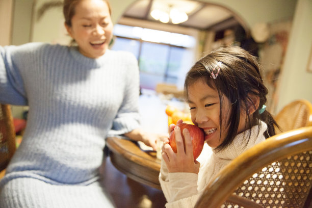 年轻的日本女孩和她怀孕的母亲一起吃苹果图片下载