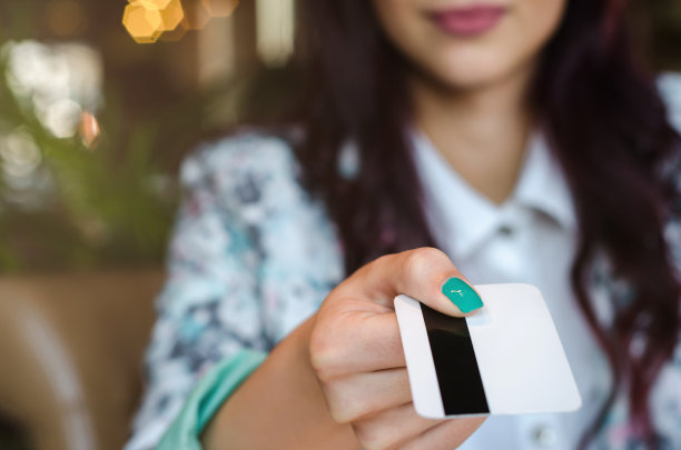 年轻女子用信用卡付账。图片下载