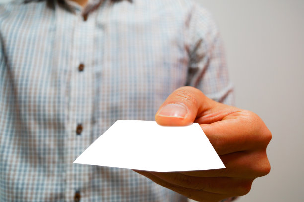 一个男人拿着一张白色背景的名片图片下载