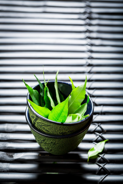 黑色的桌子上放着茶壶，味道鲜美的绿茶图片下载