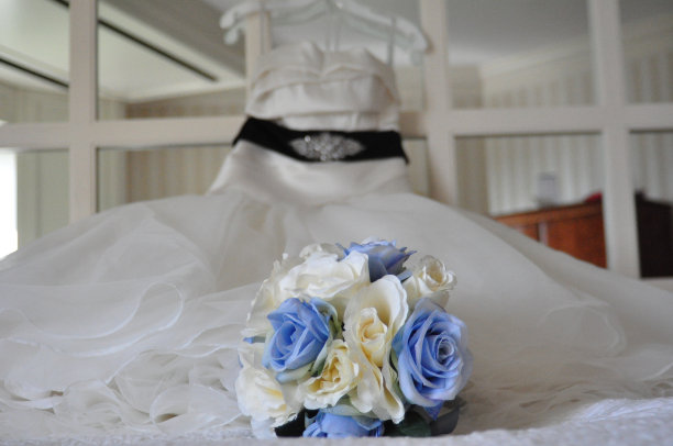 床上的婚礼花束，镜子床头板上的婚纱图片下载