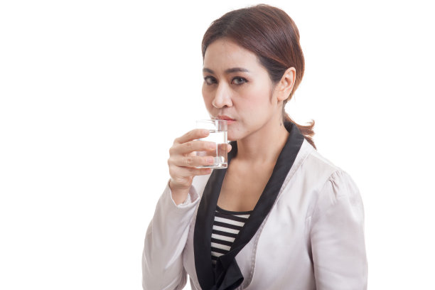 年轻的亚洲女人拿着一杯饮用水。图片下载