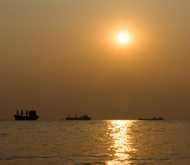 夕阳下，海上船只的剪影图片下载