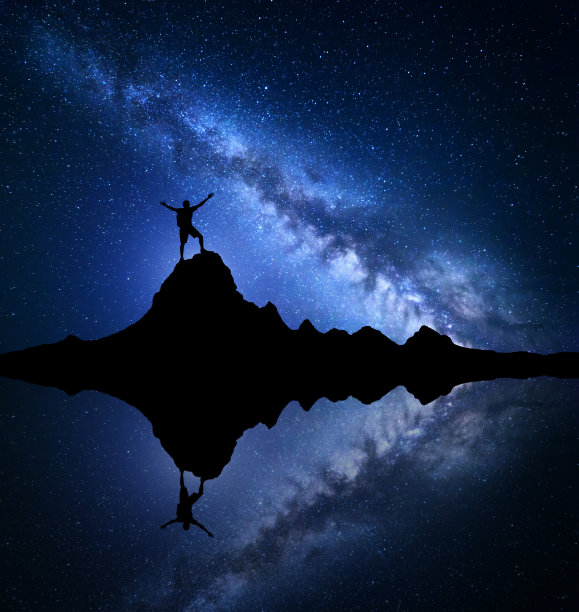 银河系。岩石上一个快乐的人的剪影图片下载