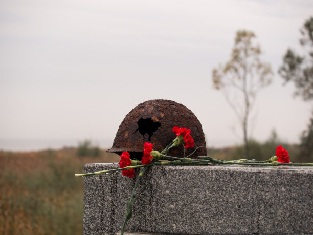 旧的生锈的军用头盔上有一个大洞，躺在那里作为纪念图片下载