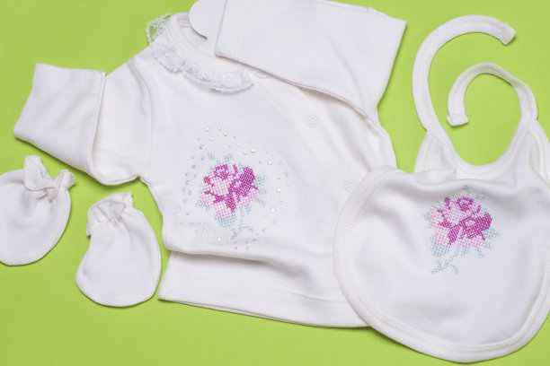 浅绿色背景的新生女婴的衣服。图片下载