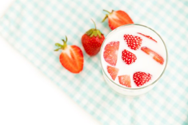 健康早餐:一杯新鲜的牛奶和美味的成熟草莓图片下载