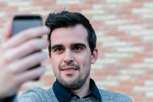 一个用手机做自画像的人图片下载