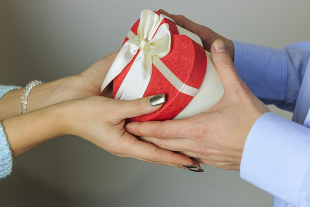 一个年轻人送给她一个心形的礼物图片下载