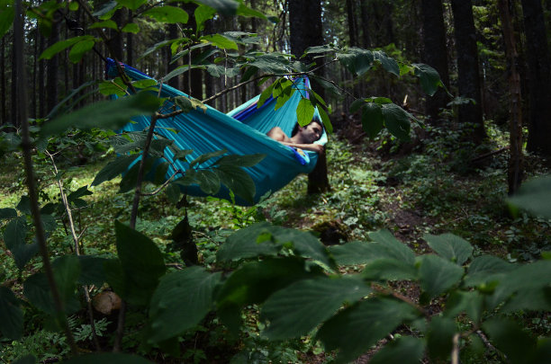 森林里，一个人躺在吊床上休息图片下载