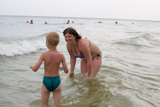 快乐的女人和一个男孩在海上图片下载
