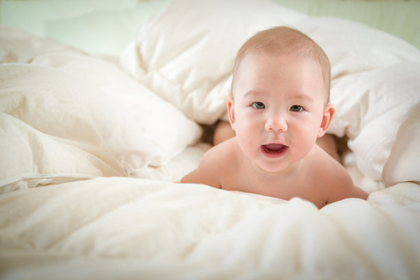 混血男婴在毯子上玩得很开心图片下载