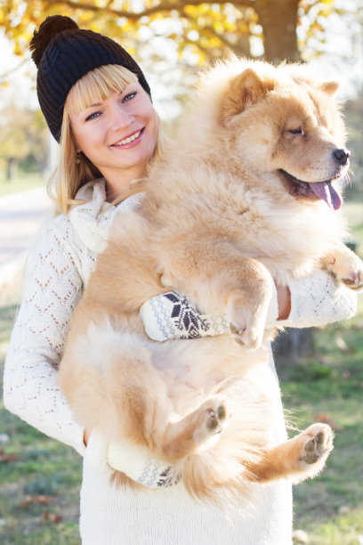 迷人的女孩和她的狗穿着暖和的衣服图片下载