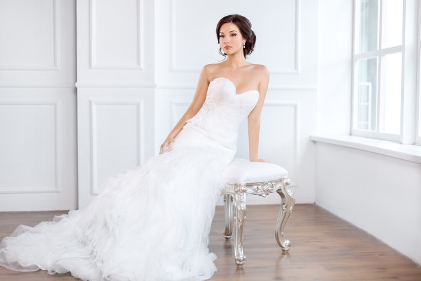 新娘穿着漂亮的礼服坐在室内的椅子上图片下载