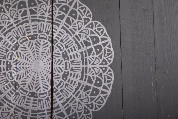 白色曼荼罗在深色木制背景上图片下载