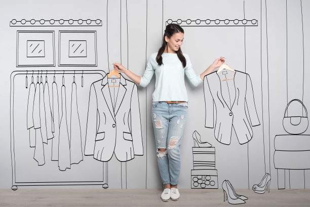 快乐的女人拿着衣架上的衣服图片下载