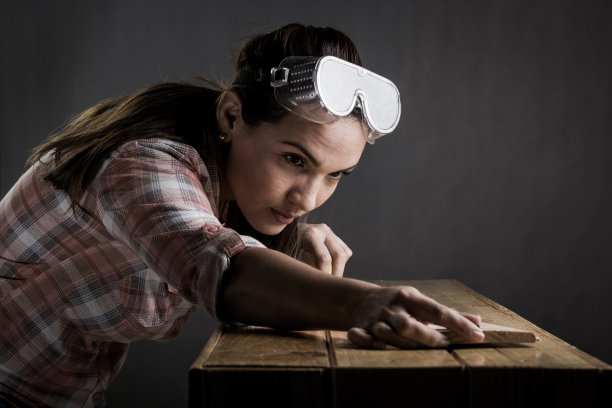 用卷尺量木板的妇女素材图片