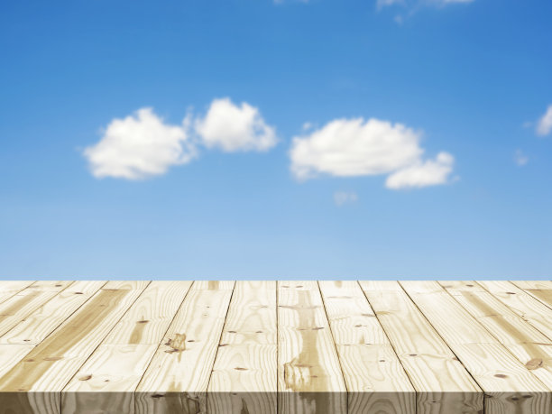 抽象的背景。木质桌面上模糊了蓝色的天空。图片下载
