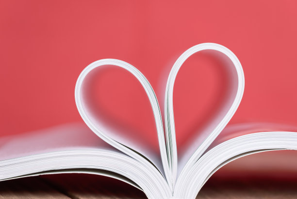 情人节心形的书页与红色的背景。图片下载