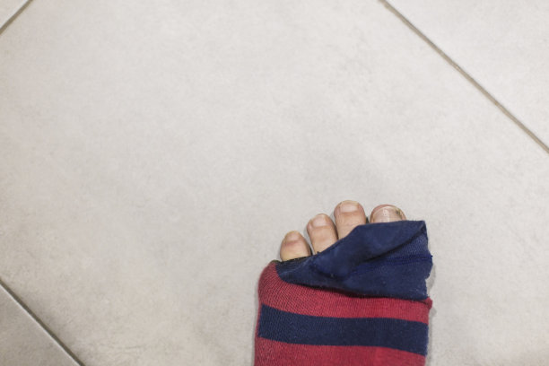 一双脏脚踩在深蓝色破袜子上图片下载