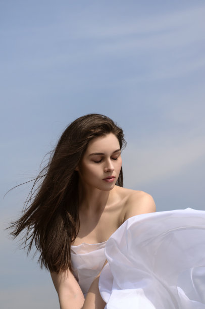 女孩手里拿着织物在风中飘扬图片下载