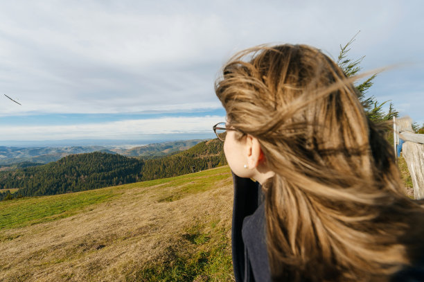 年轻漂亮的女子戴着眼镜凝望着群山图片下载