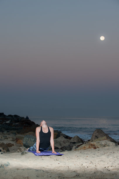 倾斜的女人在图案紧身衣表演背部伸展在晚上。图片下载