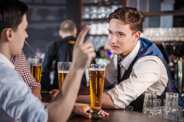 自信的男人在酒吧喝啤酒。男人拥有玻璃图片下载