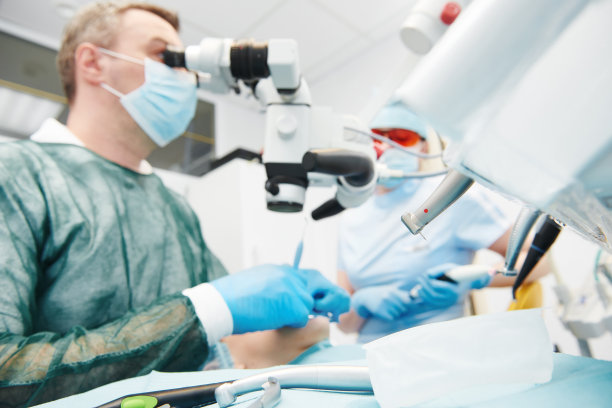 牙医在牙科诊所用显微镜工作图片下载