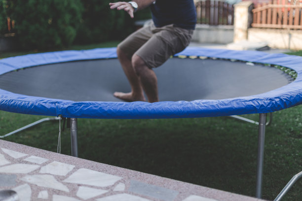 男性在后院的蹦床上跳图片下载