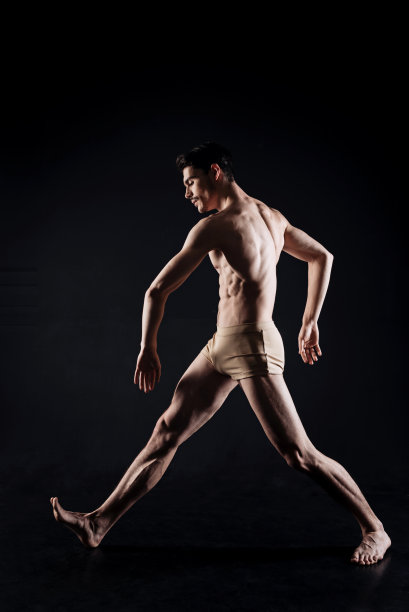 年轻的艺术表演者在黑色的工作室表演图片下载