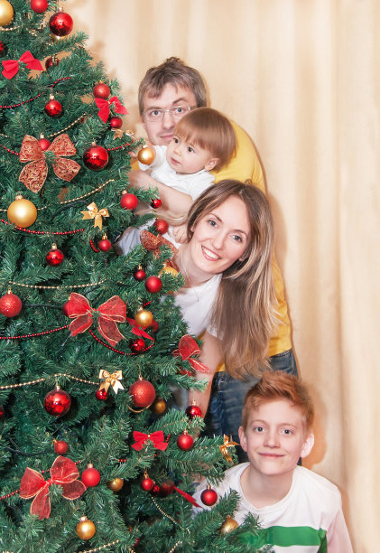 圣诞树旁幸福微笑的家庭肖像。图片下载