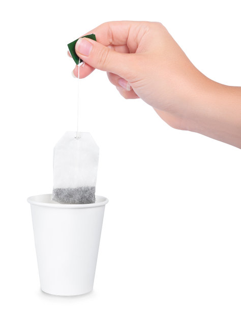 茶杯和手持的茶包上隔离白色图片下载