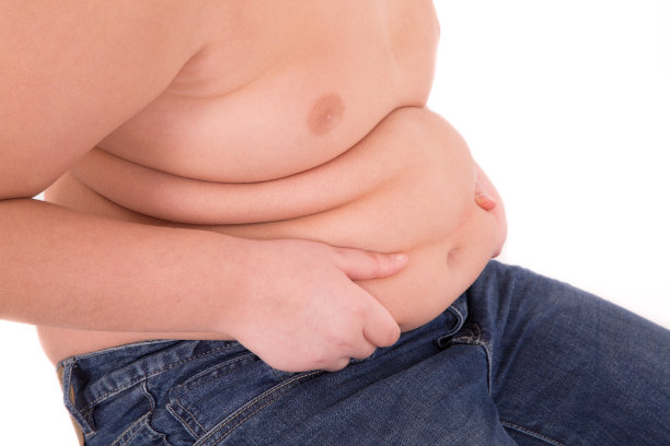 胖男孩用手摸摸他的肚子图片下载