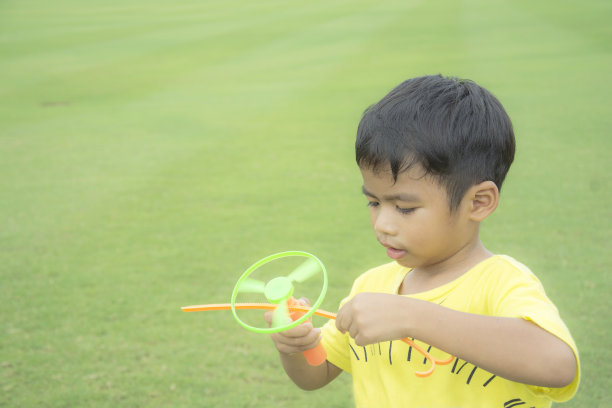 一个小男孩在绿色公园里准备射击玩具图片下载