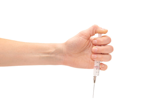 女性手持注射器。孤立在白色的。图片下载