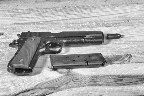 9毫米手枪和子弹散落在桌子上。图片下载