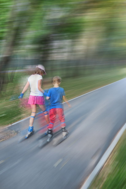 小女孩和小男孩溜冰。运动模糊。图片下载