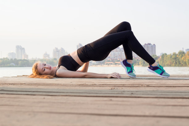 年轻女孩在户外训练时做臀部塑形练习图片下载