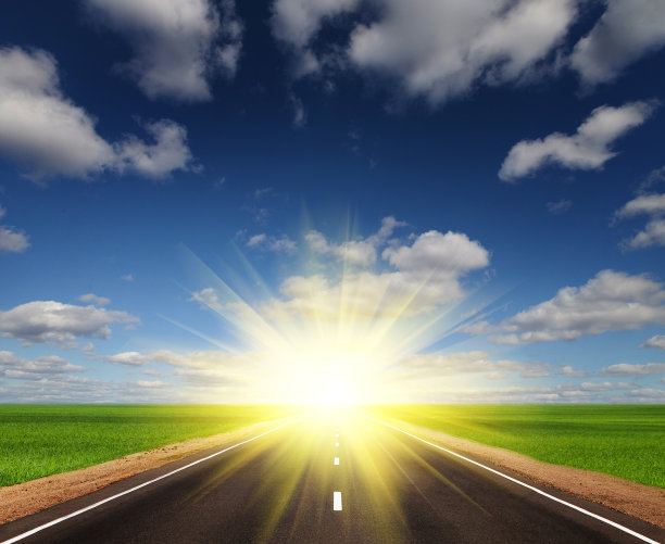 美丽天空下绿色田野里的柏油路图片下载