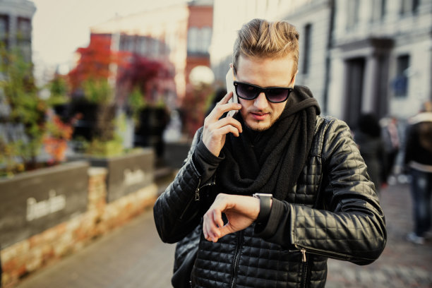 男人一边打电话一边看智能手表图片下载