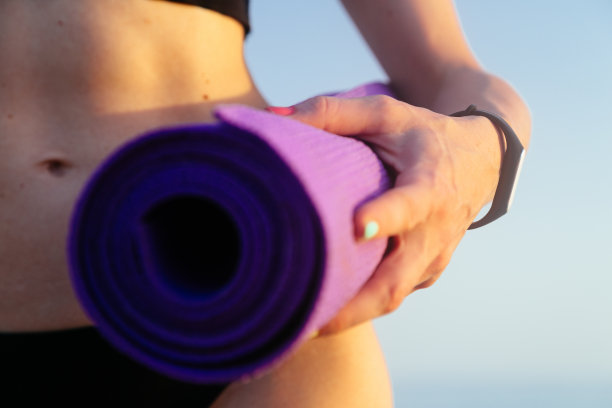 女人用完美的身体抱瑜伽垫。健康生活理念。图片下载