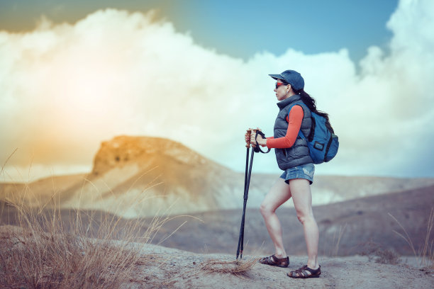 年轻的旅行者背着背包站在巨石上图片下载